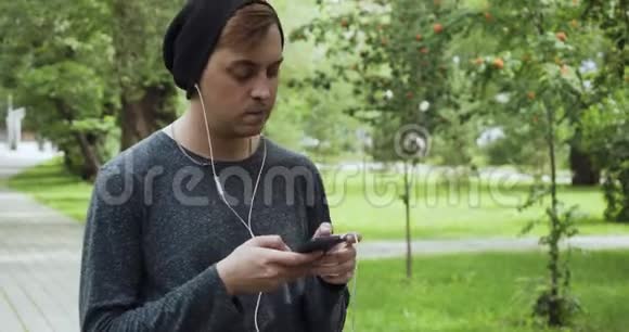 希普斯特在夏季公园听智能手机音乐视频的预览图