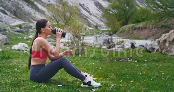 在大自然中锻炼后女士渴了喝点水休息一下用智能手机找一个视频的预览图
