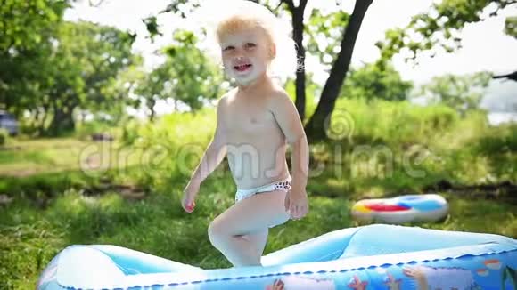 快乐的女婴小孩跳在充气床垫上慢动作高清夏季视频的预览图