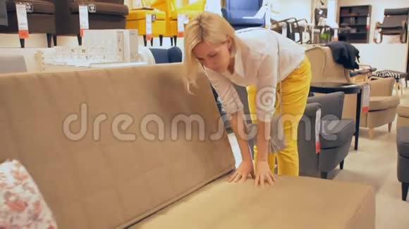 一个女人在商店的沙发上选择一张床视频的预览图