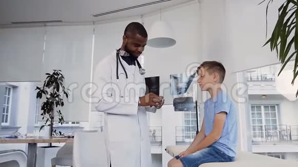 可爱的小男孩向看着他喉咙的年轻医生张开嘴视频的预览图