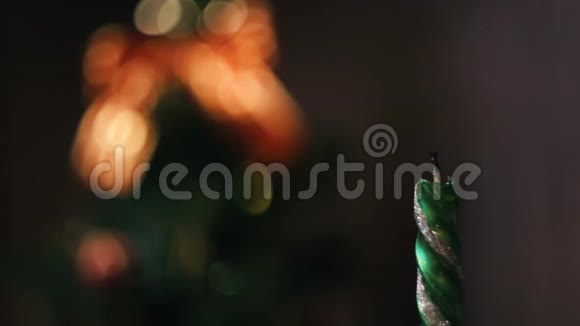 在模糊的圣诞树轮廓上用灯光和装饰特写灭绝的圣诞蜡烛概念视频的预览图