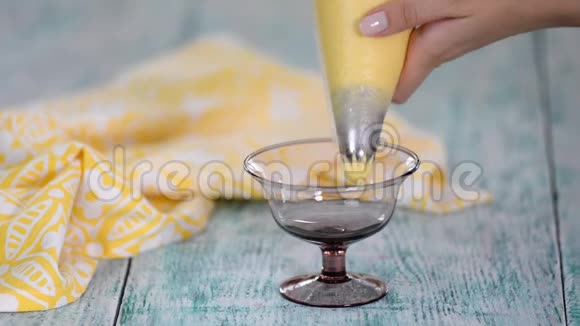 厨师正把奶油挤在玻璃碗里视频的预览图