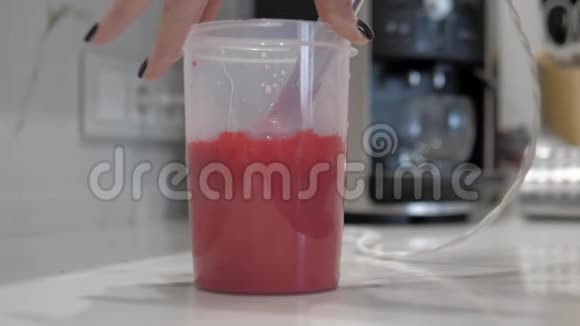 女用手将粉红色液体与红色油漆塑料瓶搅拌器特写混合视频的预览图