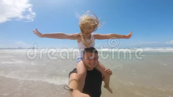 在一场海上风暴中快乐的父亲和女儿在海滩上玩耍友好家庭旅游生活方式的概念视频的预览图