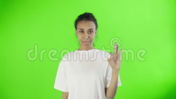 可爱的非裔美国女孩在演播室的关键背景上用两个拇指和微笑表现得很好视频的预览图