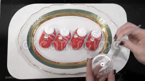 女性手工装饰的红色甜点白色条纹银饰视频的预览图