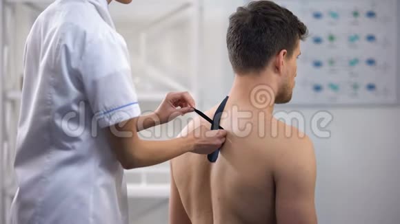 医生在病人上背部使用Y形胶带减少肌肉紧张视频的预览图