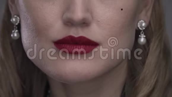 一个涂着红色口红的金发女人咬着嘴唇4K视频的预览图