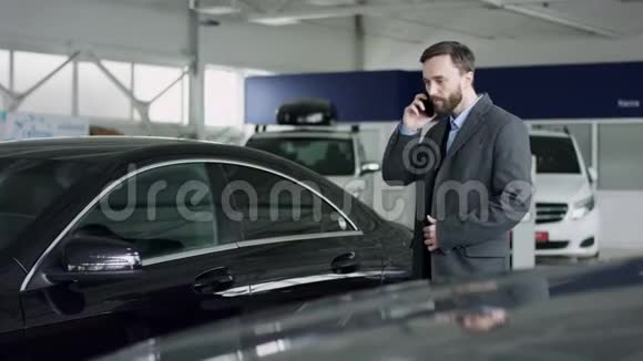 专业的汽车销售人员告诉有兴趣的买家在车展上豪华的汽车而男人正在与经销商交谈视频的预览图