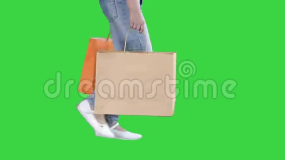 活泼开朗的女孩带着购物袋走在绿色屏幕上Chroma键视频的预览图