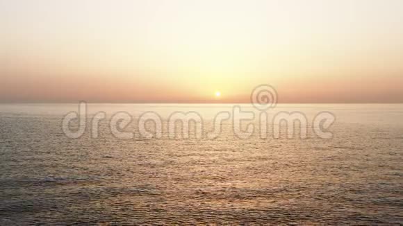 静态宽阔的空中背景拍摄涟漪的海浪和太阳下山令人惊叹的橙色日落心情全景视频的预览图