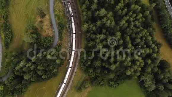 俯视图无人机跟踪史诗般的红色冰川快车沿着宁静的夏天瑞士阿尔卑斯山乡村巡航视频的预览图