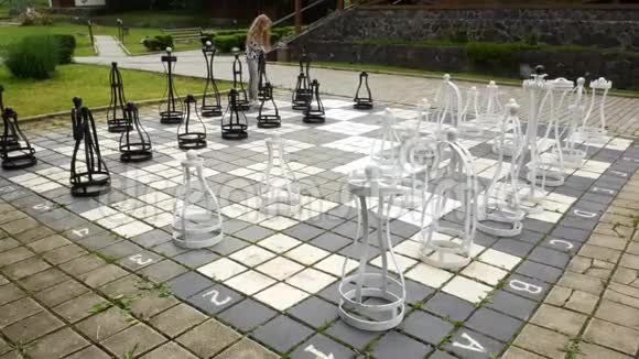 院子里的大棋盘孩子重新排列沉重的棋子视频的预览图