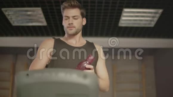 微笑的男性跑步者给适合健身健身房女性的饮料瓶视频的预览图