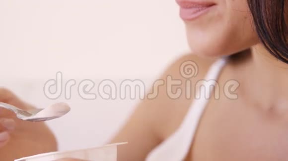 靠近一个喝酸奶的棕色女人视频的预览图