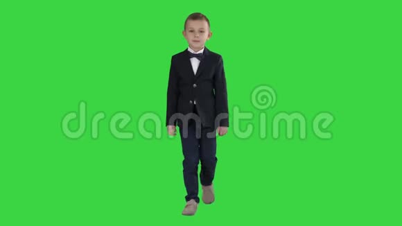 穿着制服的小男孩带着蝴蝶结走在绿色屏幕上Chroma键视频的预览图