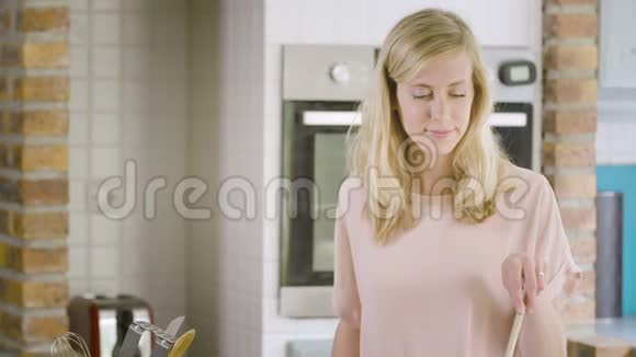 靠近厨房做饭的年轻女人在她的智能手机里寻找食谱视频的预览图