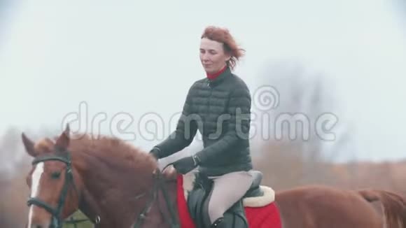 两个骑马的女人牵着她们的缰绳视频的预览图