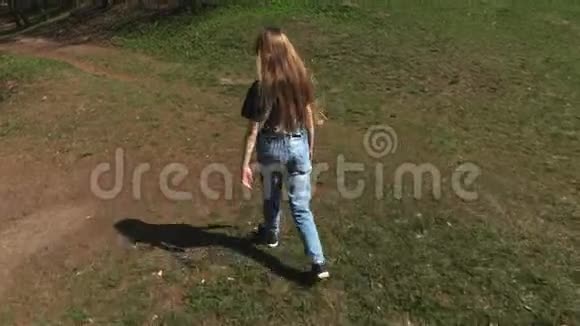 阳光明媚的日子公园小路上的小女孩视频的预览图