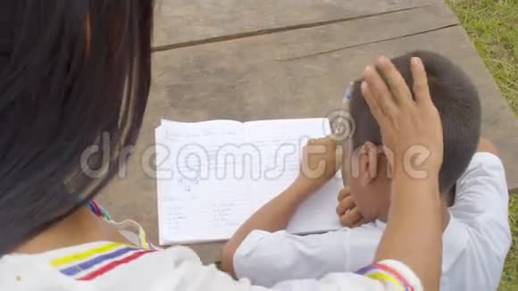 年轻的土著妇女帮助小男孩做家庭作业视频的预览图