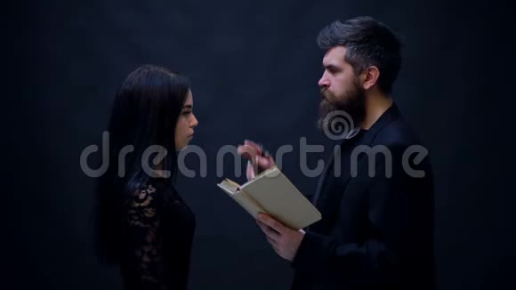 神父承认女孩被隔离在黑色奇怪的牧师把圣经和修女一起握在手里孤立在一个视频的预览图