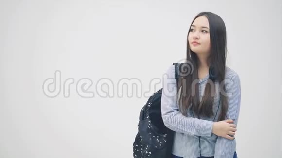 情绪激动的年轻亚洲女孩正在打电话讨论一些问题挥动她的手看上去心烦意乱她身上的背包视频的预览图