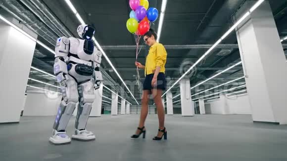 开朗的女人把气球送给自动机器人视频的预览图