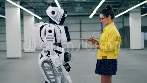一个女人检查机器人的工作在平板电脑上打字视频的预览图