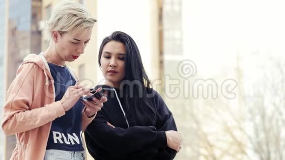 两个不同国籍的年轻女性多民族的朋友使用智能手机视频的预览图