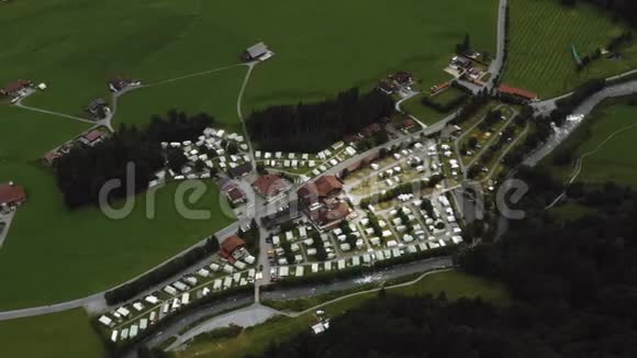 俯瞰空中背景拍摄美丽的小村庄在绿色山谷之间的山脉之间雄伟的瑞士阿尔卑斯山视频的预览图