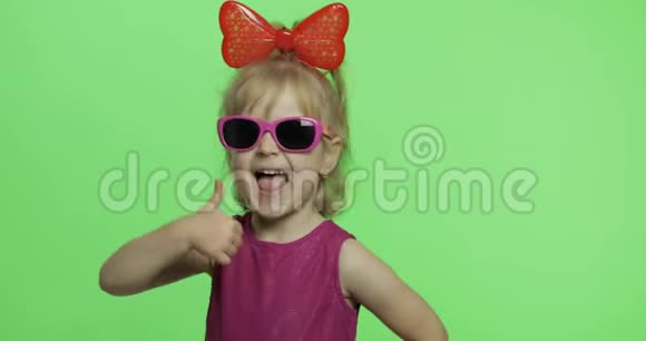 穿紫色连衣裙的女孩太阳镜和红色丝带竖起大拇指色度键视频的预览图
