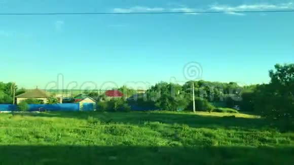 风景从火车的窗口绿色的风景田野山丘和村庄视频的预览图