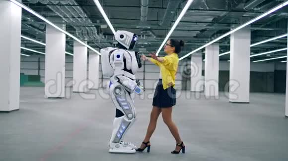 机器人和女人拥抱在一起站在一个空荡荡的房间里视频的预览图