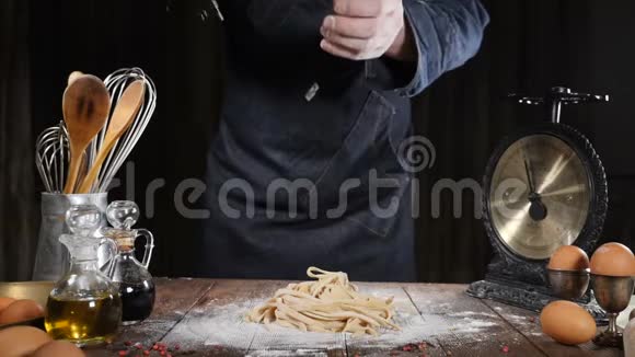 手在黑色背景的木板上倒面粉厨师手指在面粉中缓慢运动烹饪披萨和意大利面视频的预览图