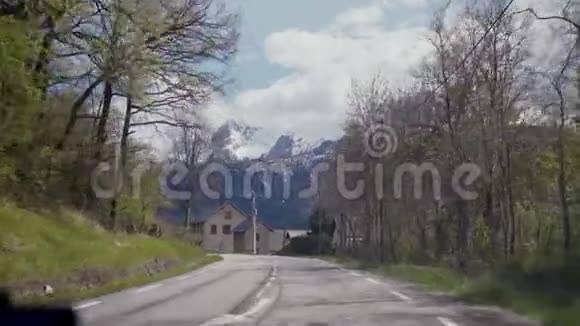 开车旅行车骑在美丽的乡村道路上带着美丽的山景从玻璃中看到视频的预览图