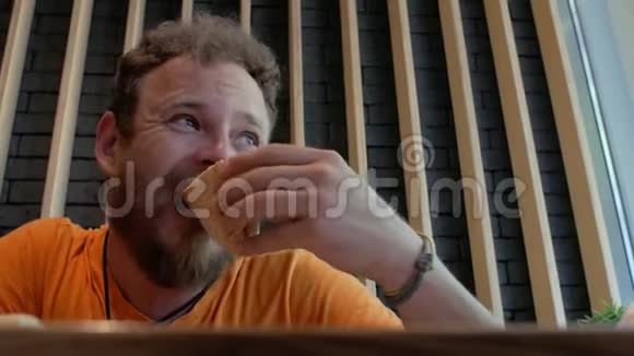 留着胡子的男人在咖啡馆里吃披萨然后彻底咀嚼4k4k视频视频的预览图