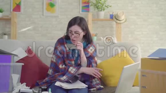 商业女性工作狂病打喷嚏坐在沙发上在家工作的画像视频的预览图