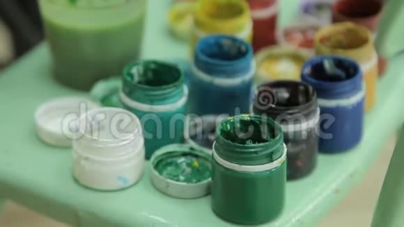 一套多种颜色的泥在塑料罐子上旋转多色背景很多水纹漆水罐视频的预览图