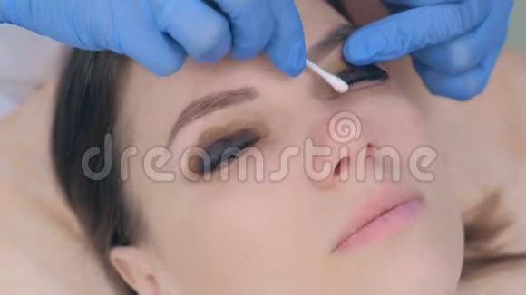 美容师擦拭棉棒油漆从睫毛分层提升程序视频的预览图