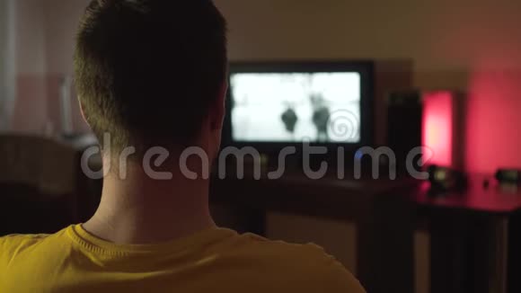 一个男人深夜在客厅看电视一个人坐在他的背框里借着灯的光视频的预览图