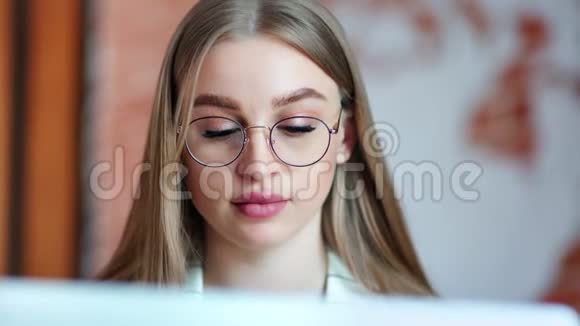 美丽忙碌的年轻商务女性戴着眼镜看着笔记本电脑屏幕视频的预览图