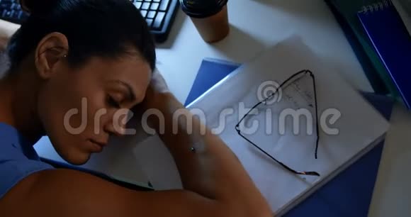 现代办公室中年轻白种女性主管睡在办公桌上的高角度视角4k视频的预览图