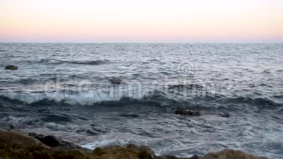 波在地中海上波浪在粉红色日落时撞击岩石慢动作视频的预览图