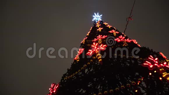 从底部观看美丽的圣诞树与节日装饰和花环的多色灯光对视频的预览图