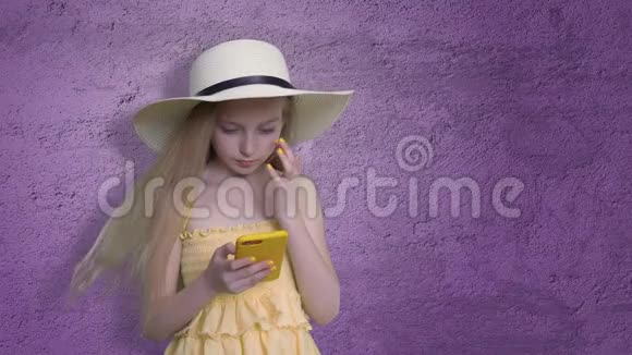 紫罗兰背景下用手机拍照的女孩视频的预览图