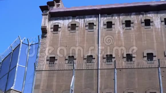 铁丝网后面的一座监狱建筑的墙视频的预览图