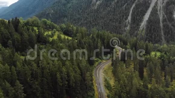 俯视空中拍摄的铁路轨道穿越雄伟的夏季瑞士阿尔卑斯山山脉流浪的概念视频的预览图