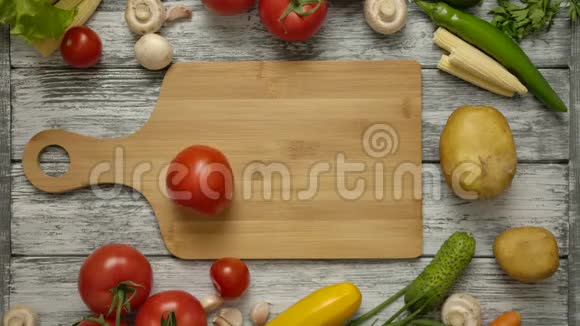 番茄在乡村餐桌上的木切割板上旋转视频的预览图