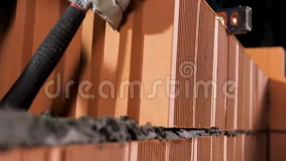 工业工人用橙色砖块和砂浆建造外墙库存录像一个砖匠把另一个视频的预览图